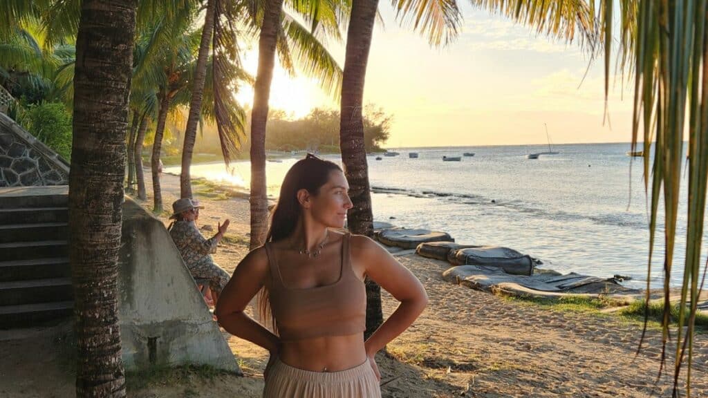 femme qui regarde sur le côté sur une plage à l'ile maurice au coucher de soleil